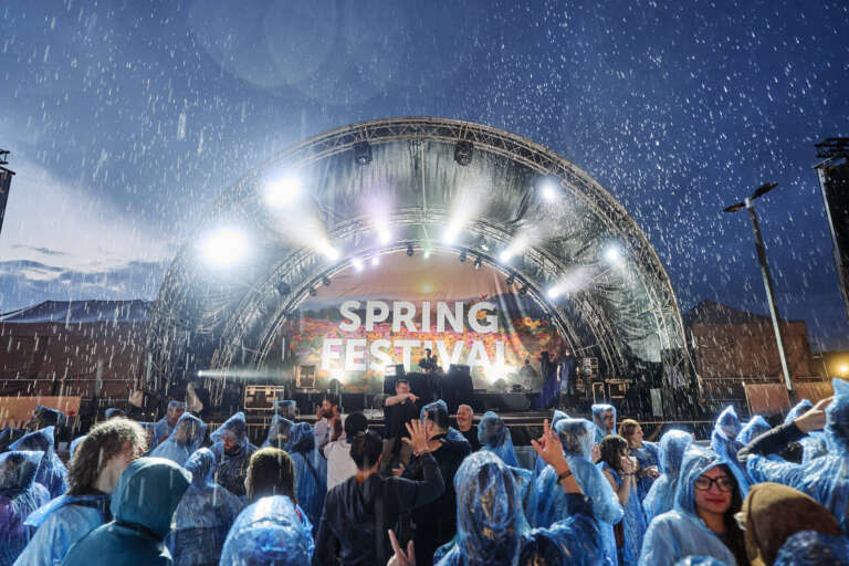 Nighttime view of the Spring Festival stage during a downpour.