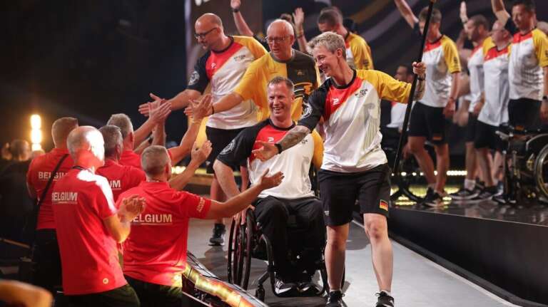 Atleten doen high five met mensen naast het podium tijdens Invictus Games in Düsseldorf door OVAL.