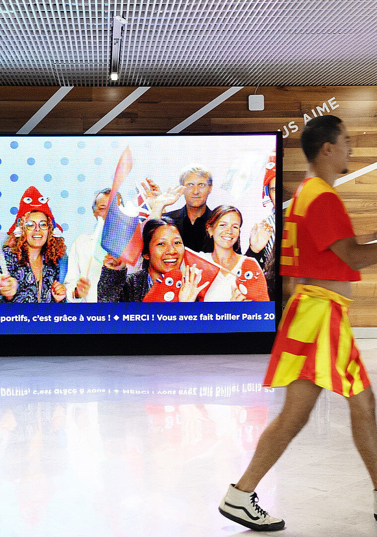 Joyful portraits of supporters displayed on a large screen in the terminal.