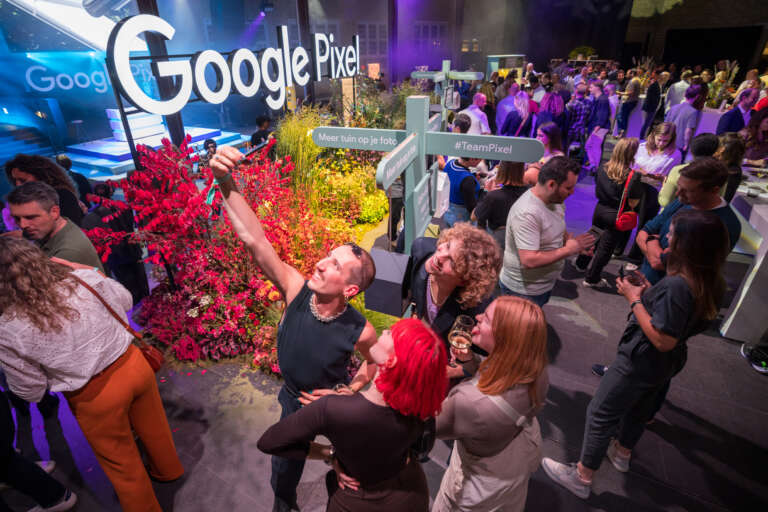 Participants taking a selfie in a space designed in the colors of Google Pixel, during a B2B event