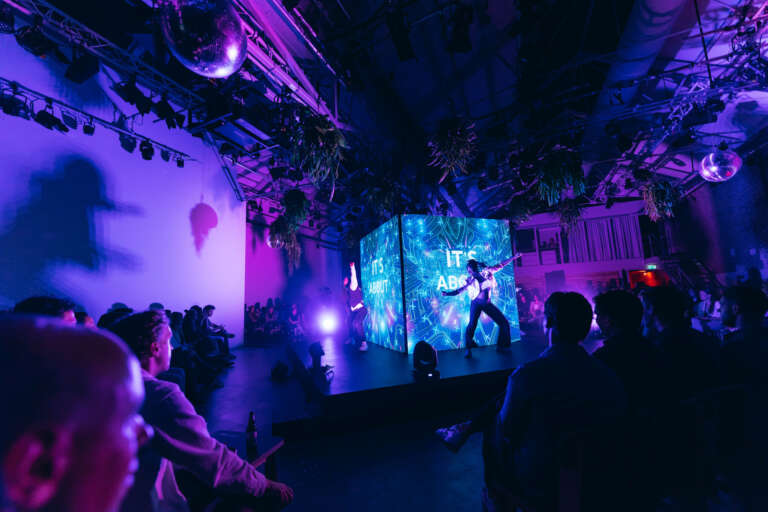 Artistic performance on stage in front of an immersive digital installation, in an innovative B2B event setting